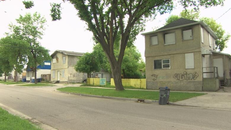 A street has multiple boarded up houses.