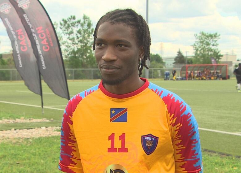 A man wearing a hockey jersey with the colours of the Democratic Republic of Congo flag.