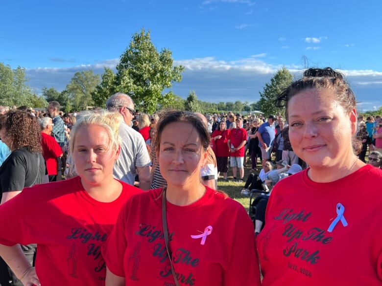 Three women wearing Light Up the Park T-shirts