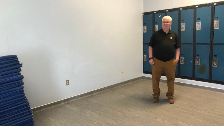 Tony Brushett stands in small room with sleeping mats in it