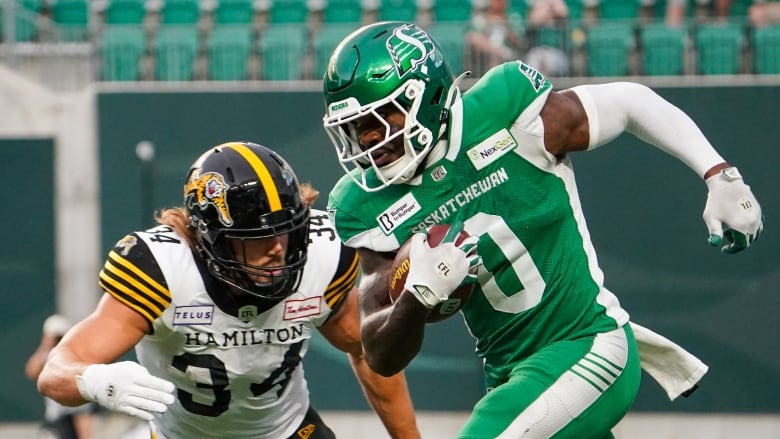 Saskatchewan Roughriders defensive back Rolan Milligan Jr. (0) runs the football after intercepting it against Hamilton Tiger-Cats during the second half of CFL football action in Regina, on Sunday, June 23, 2024.