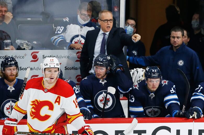 A hockey team is seen sitting on a team bench in an arena