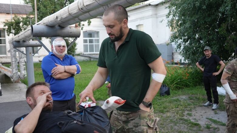 Wounded soldiers share a cigarette while waiting outside a hospital in Dnipro, Eastern Ukraine.