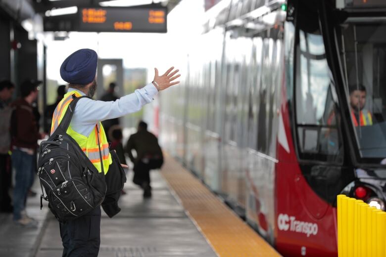 An LRT operator waves at the driver of incoming train.