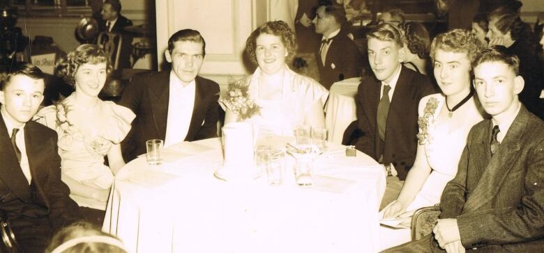 A black and white photo from November 1950 photo shows Donald Sutherland and six of his classmates from Bridgewater High School dressed in formal wear. 