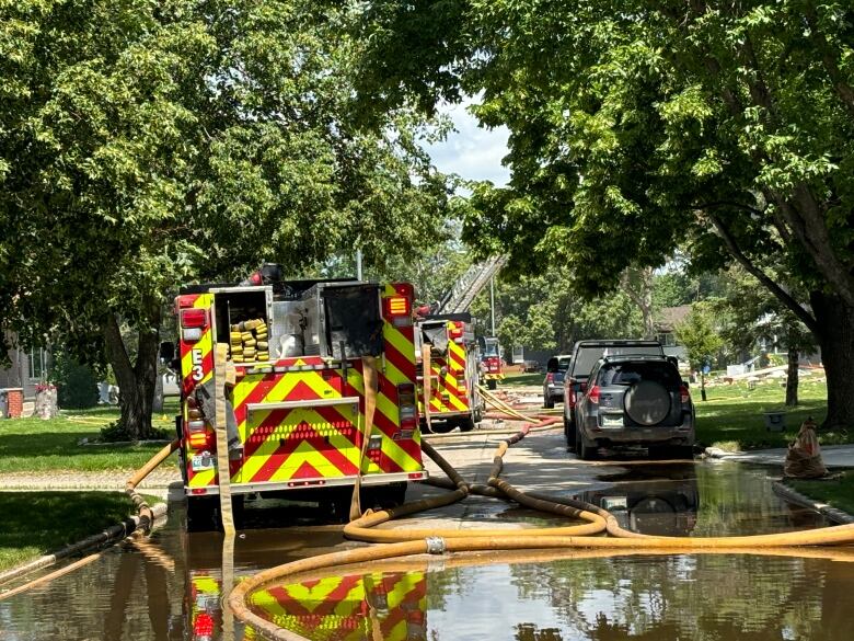 Fires trucks stand on a watery street