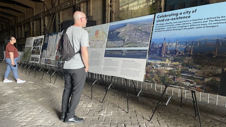 People inside a big warehouse look at big photo displays