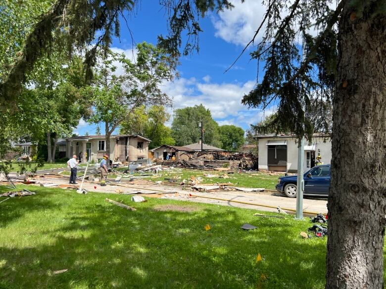 There is a pile of rubble in a yard where a house used to be after it exploded. 