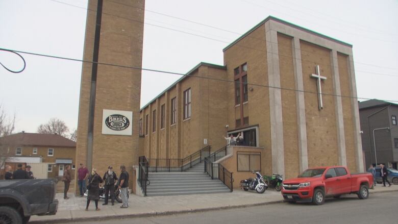 A large building with a few people standing in front of it. 