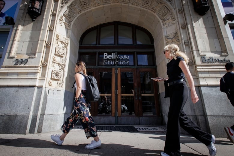 people walk by the Bell Media building