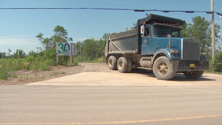 truck on a dirt road near a sign