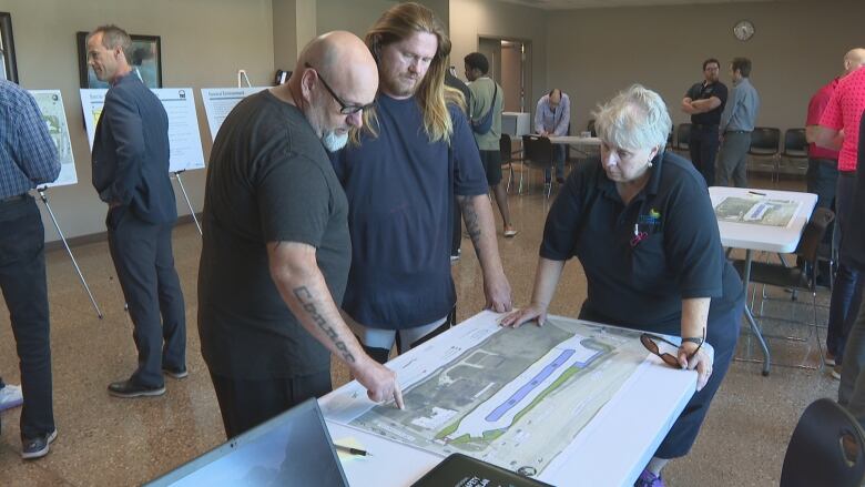 People look over a map with plans