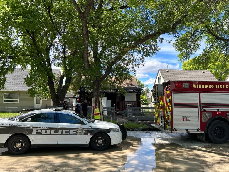 One police vehicle and one firetruck can be seen outside a home. 