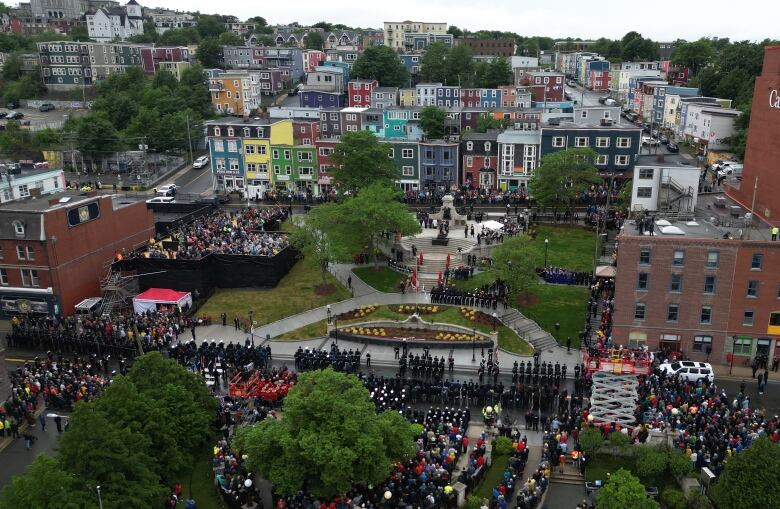 An aerial image showing crowds gathered around a park and monument surrounded by trees and buildings.