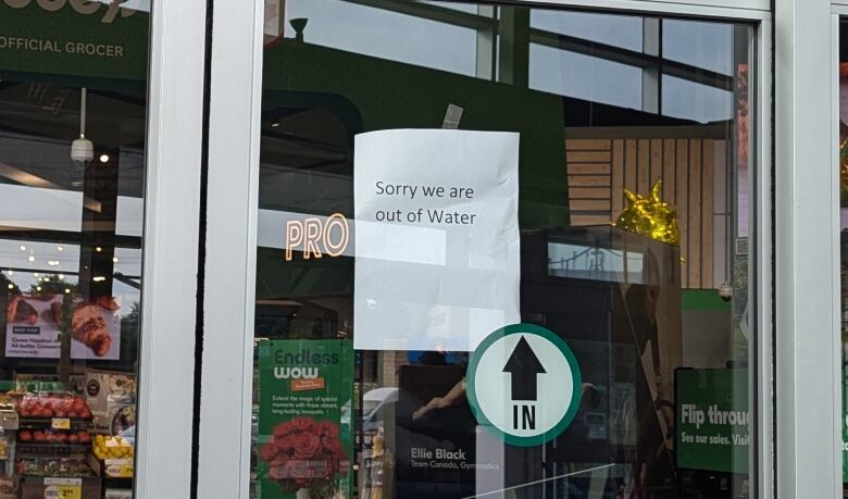 The doors to a grocery store with a sign that reads 