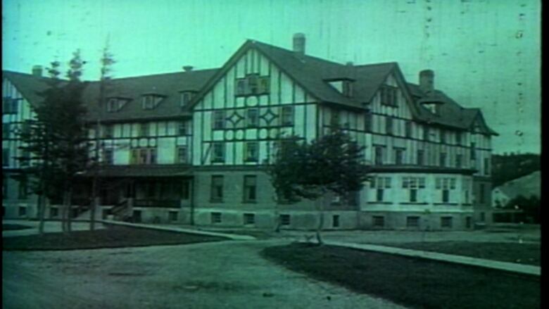 An old, green tinted picture of the hotel.