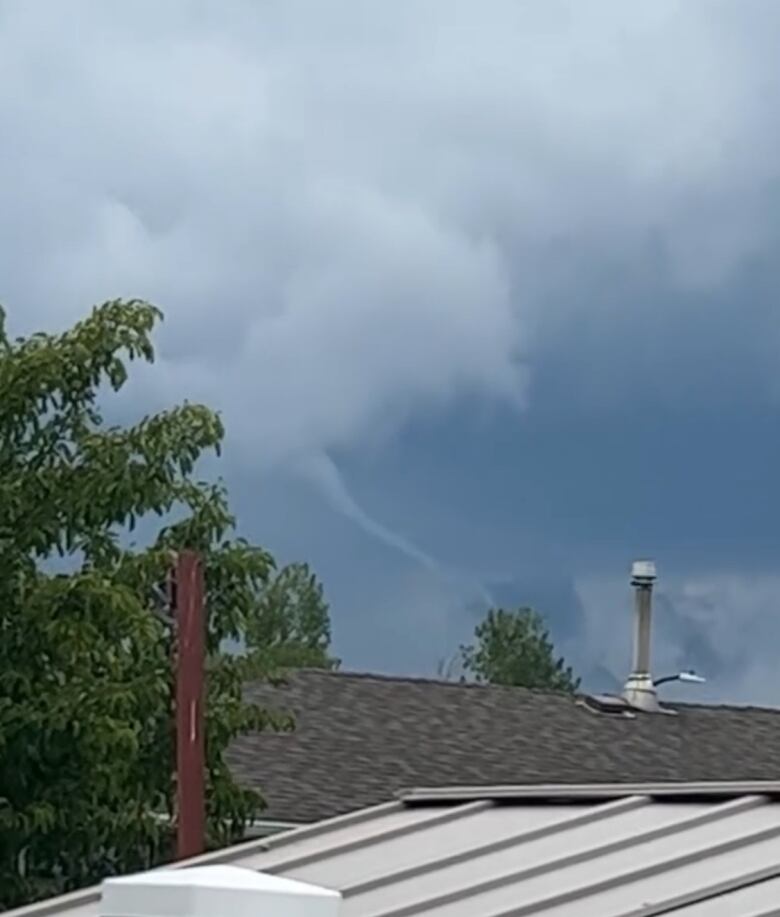 a white funnel cloud is forming in the distance