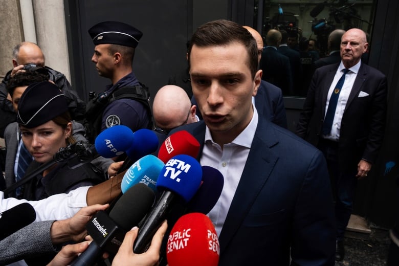 Jordan Bardella, the president of France's far-right National Rally party, is seen speaking to reporters on Paris on Monday.