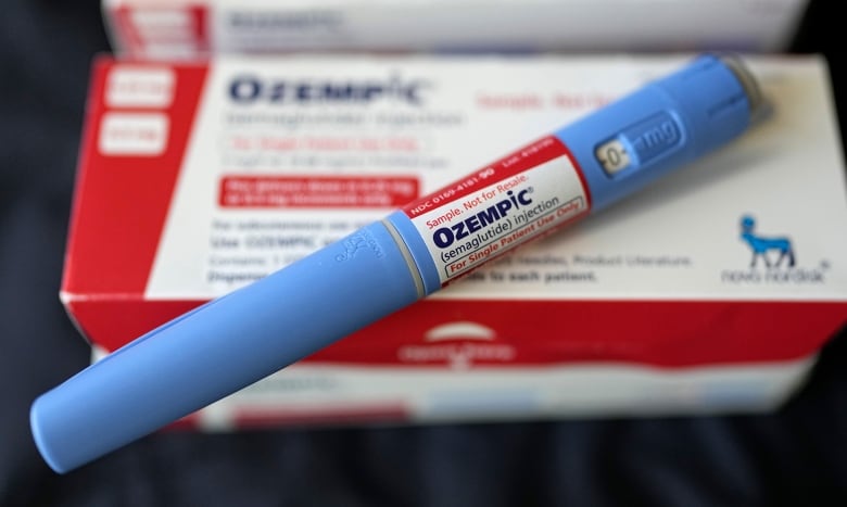 A disposable syringe bearing the name 'Ozempic' sits on a package.