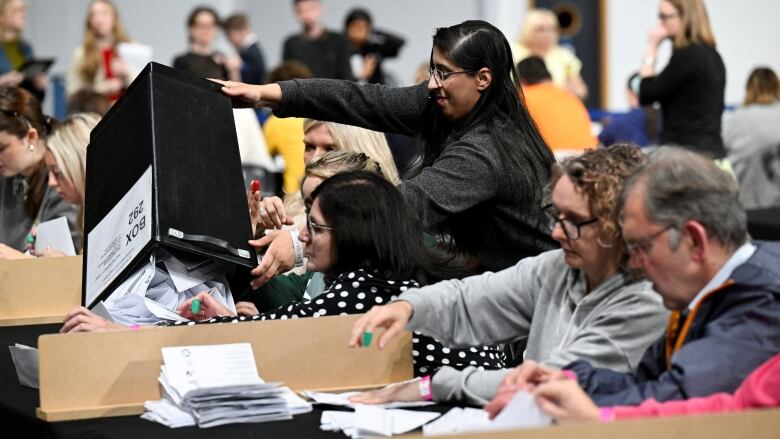 people at a vote-counting station