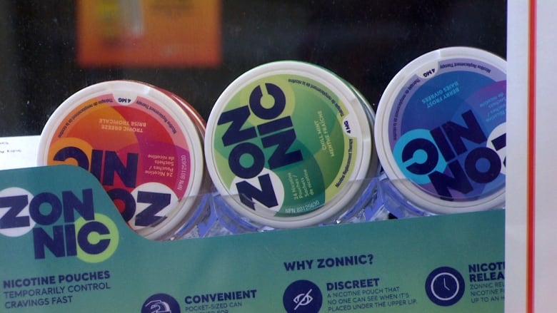 Three circular cases of nicotine pouches with the word 'Zonnic' written across the front sit in a cardboard stand.