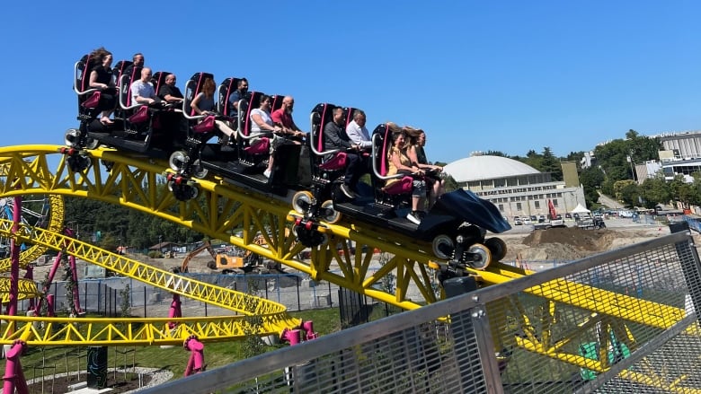 People sitting on a yellow rollercoaster