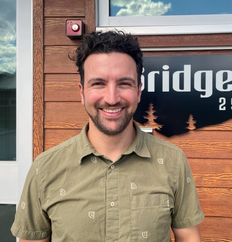 A profile shot of a man outside a cabin. 