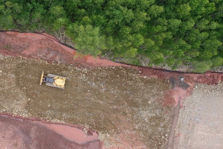 a construction vehicle drives over pile of dirt