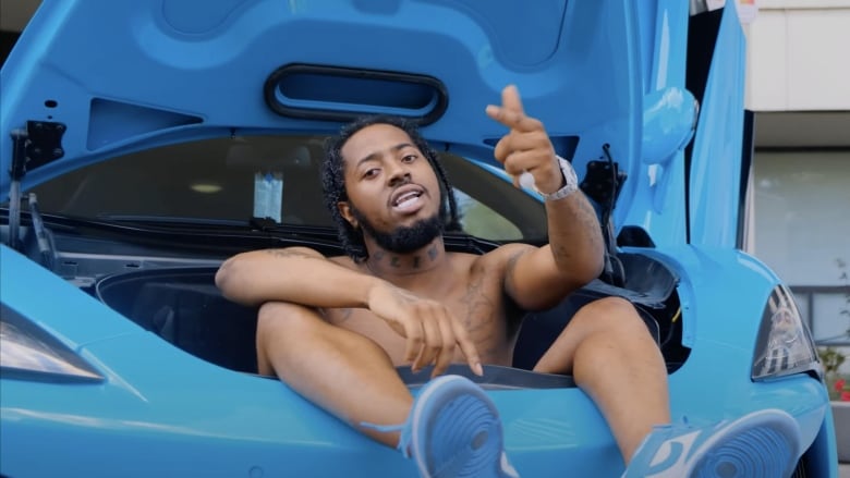 A man sitting in the front of a luxury vehicle.