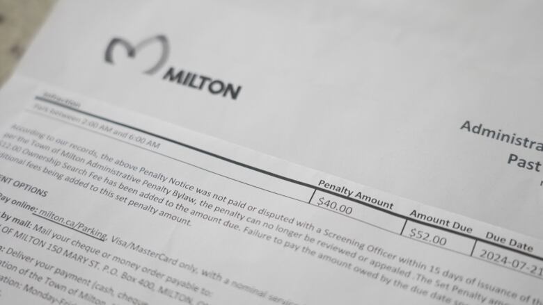 Close up of a parking ticket notice from the Town of Milton, which shows $52 as the amount due. 