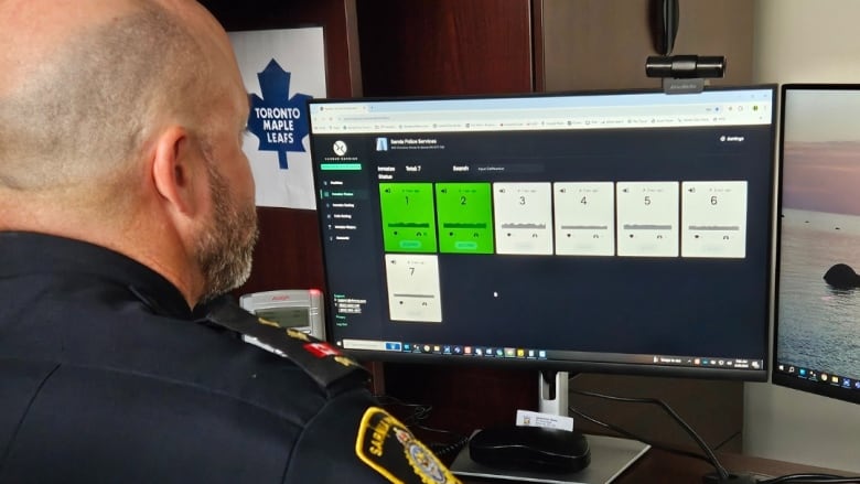 A Sarnia police officer reads data on a computer screen as part of the force's new biometric health monitoring system.