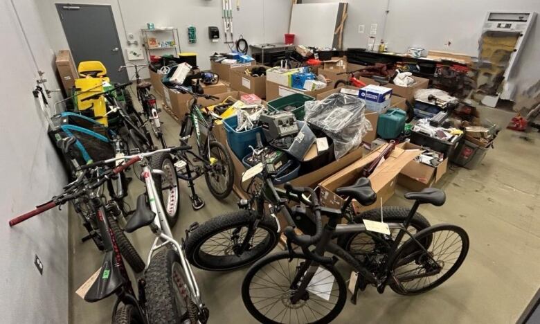 A room with boxes full of items and several bicycles.