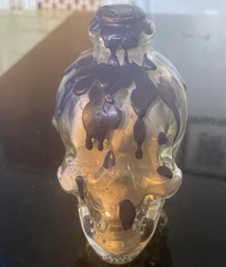 A skull-shaped pot with what appear to be ink blots across the skull.