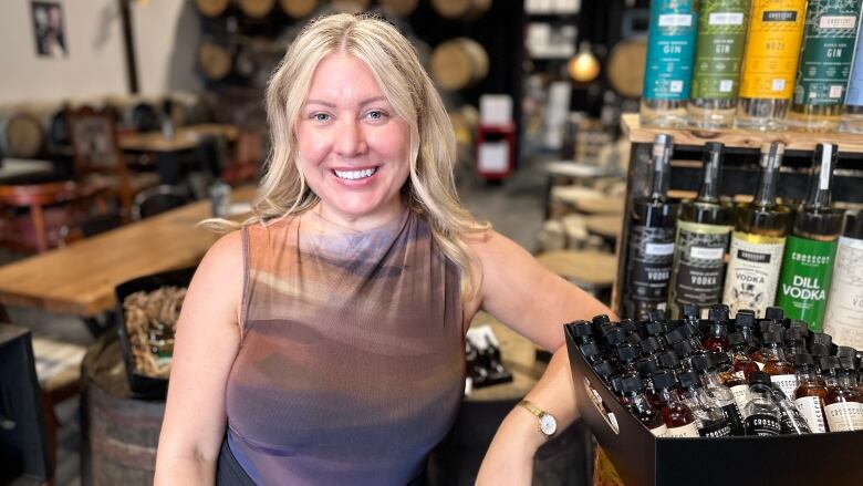 A blonde woman standing next to a bar.