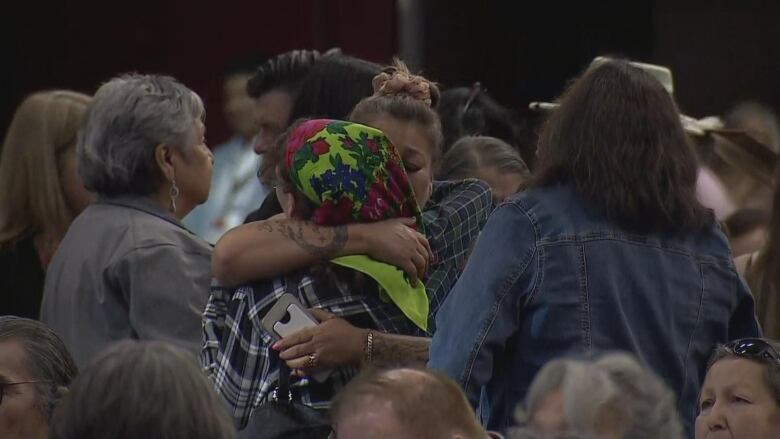 Two women hug each other. 