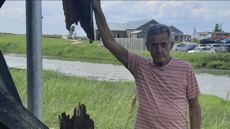 Bill Ross stands next to a rotting lighthouse that is behind his house in Pointe-du-Chne.