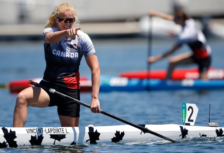 Team Canada's Laurence Vincent Lapointe of Canada points to the crowd from her boat after winning silver in the C1 200M at the Tokyo Olympics, August 5, 2021.