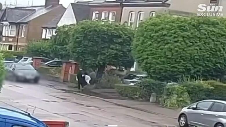 Security camera footage shows the suspect in Tuesday's attack in Bushey leaving the crime scene with what police believe was a crossbow wrapped up under his arm.