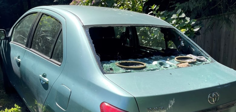 A side view of a car with its back window shattered.