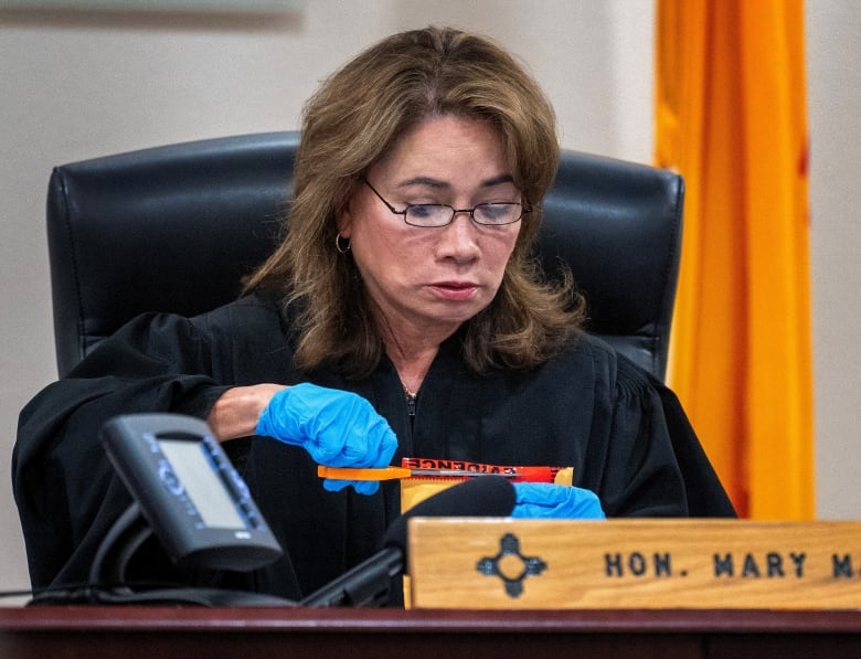 A judge cuts open an envelope.