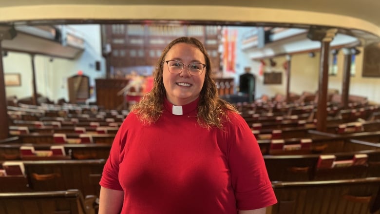 A person in a red shirt stands in a church.