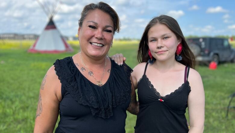 Two women smile to the camera.