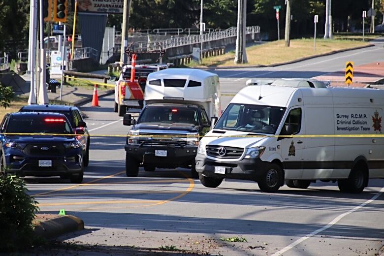 Emergency vehicles are pictured behind crime tape on city streets.