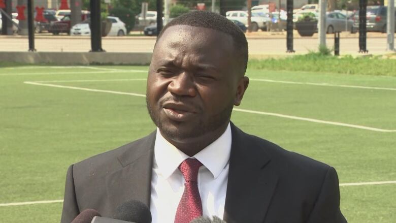 A man wearing a black suit and a red tie.