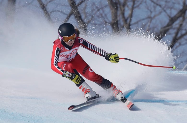 Snow flies as a skier flies down a hill.