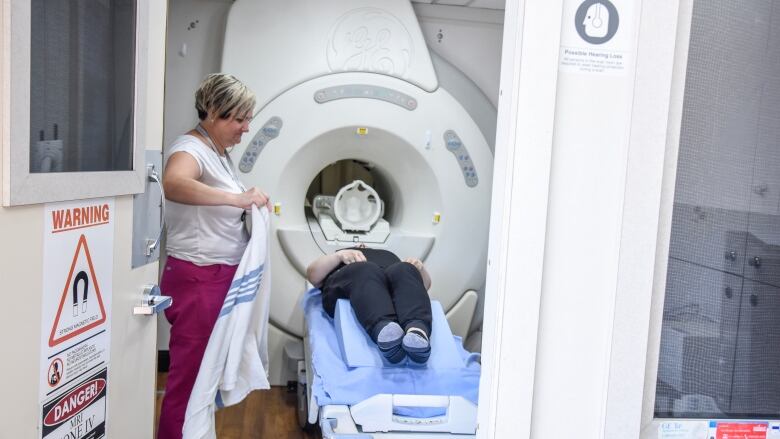 A nurse gives a patient an MRI. 