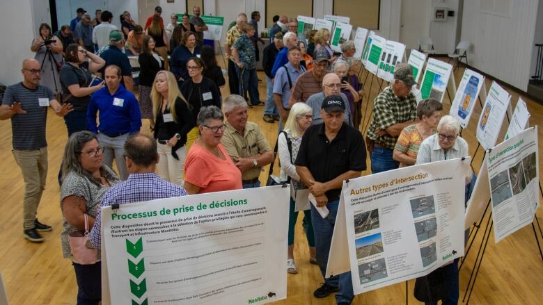 A group of people look at presentation boards.