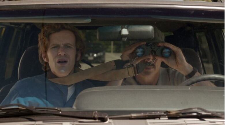 Two actors are in a car looking forward in the front seat in a scene from The Birder, a movie shot in Windsor in 2014.