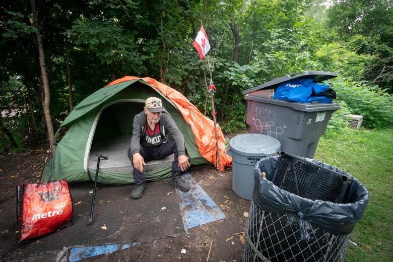 an older man sitting in front of his tent