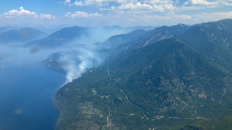 smoke coming from a fire next to a lake